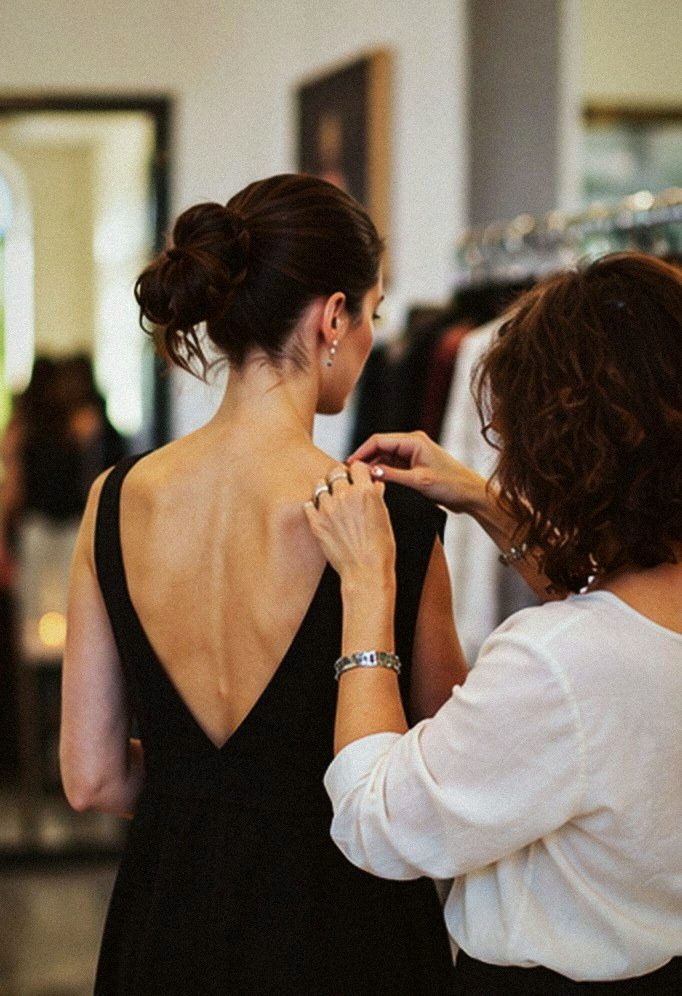 A guest in a black backless dress being styled