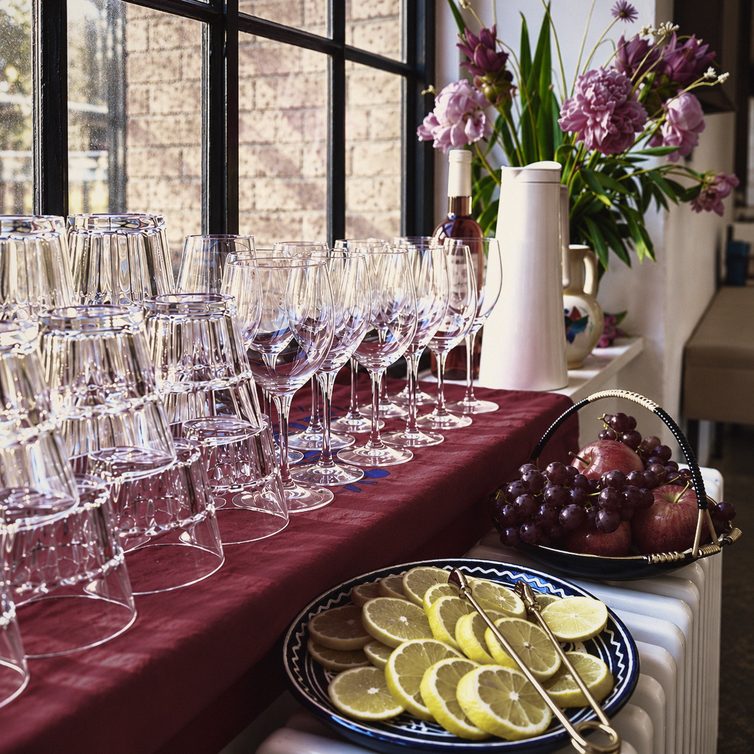 Prosecco glasses, fruit and flowers arranged on a burgundy tablecloth
